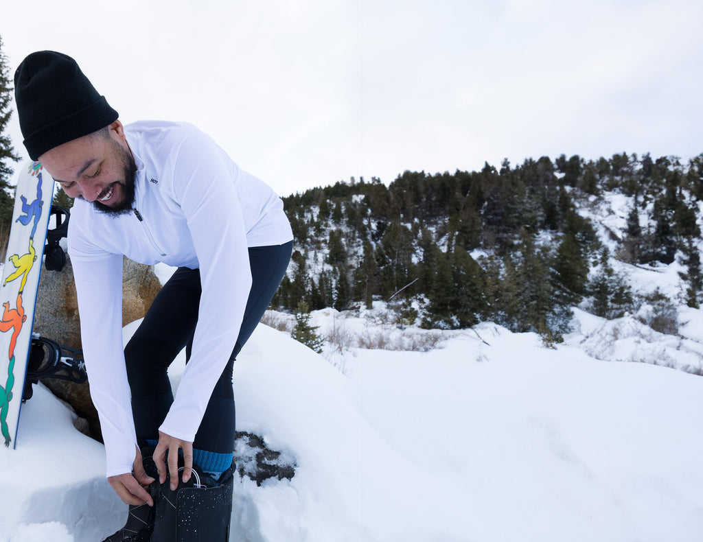 Man preparing for outdoor winter activities in men's thermal base layers from Hot Chillys in snowy landscape